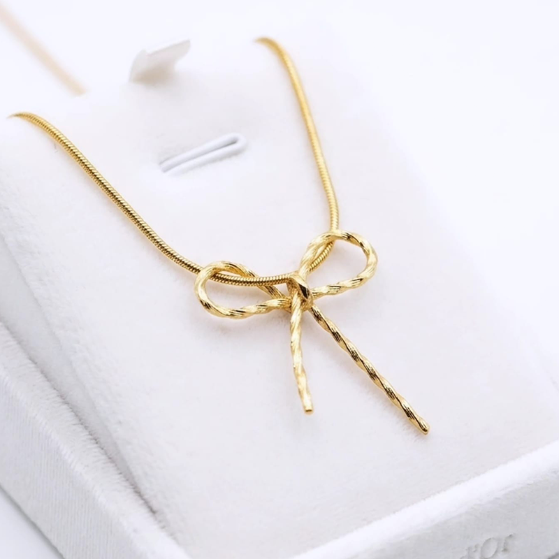 Luxurious bow shape, gold-toned pendant